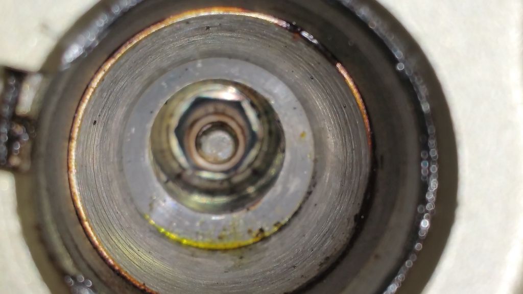 How should I clean the residue inside the coil pack/spark plug wells?